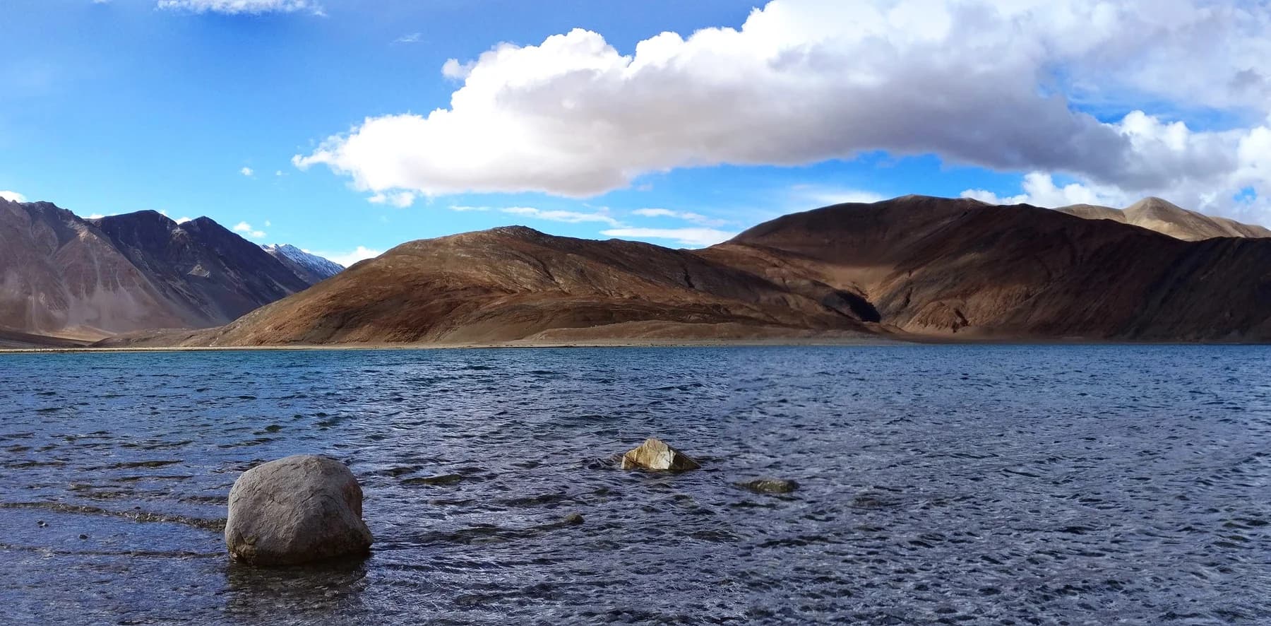 Blue water and bare mountains at Pangong Lake in Ladakh